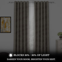 Two blackout curtains in dark gray with ivory and copper branch patterns, hanging on a silver rod, blocking 80%-90% light