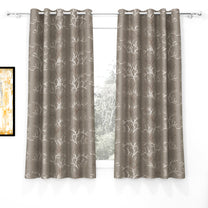 Two taupe blackout curtains with ivory and copper branch foil print, hanging on silver curtain rod with grommets