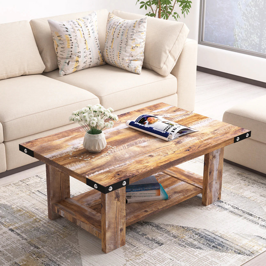 "Rustic wooden coffee table with metal accents in a living room, adorned with a vase of white flowers, magazines, and decorative pillows on a beige sofa."