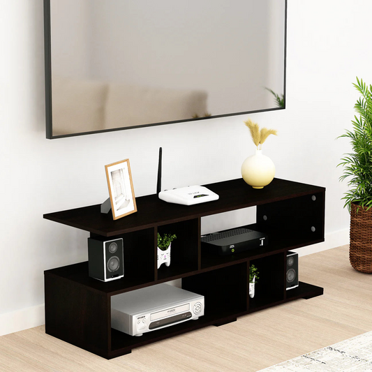 Modern living room with a TV stand holding electronics and decorative items, next to a plant.