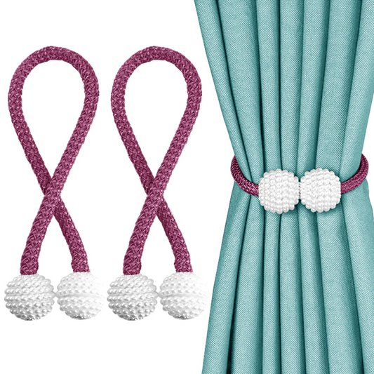 Curtain tiebacks with purple cords and white decorative balls on a teal curtain.