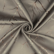 Ivory blackout curtain fabric with copper foil branches pattern, shown in a close-up twisted fold view