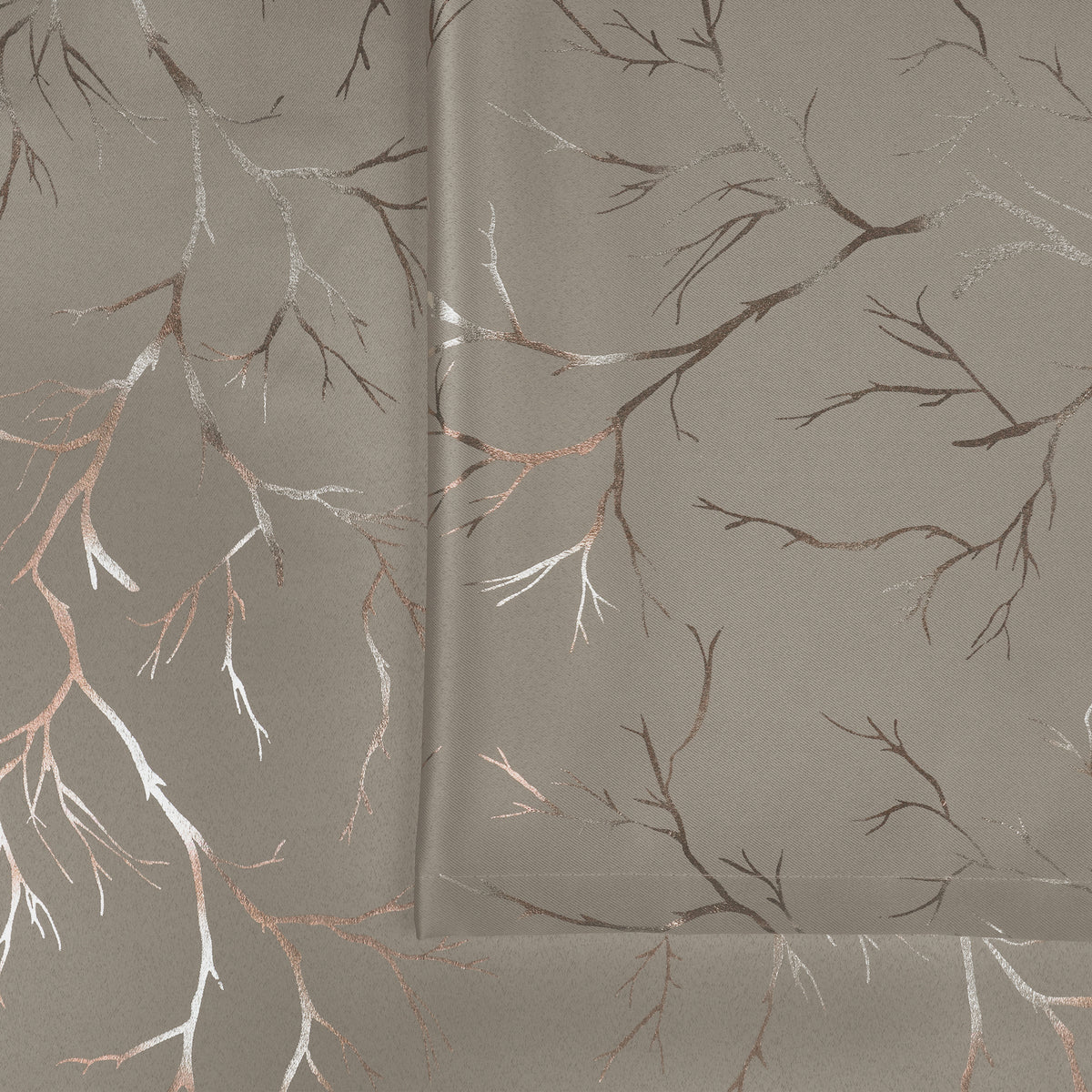Ivory blackout curtain fabric with copper and silver foil branch pattern, shown folded and flat on surface
