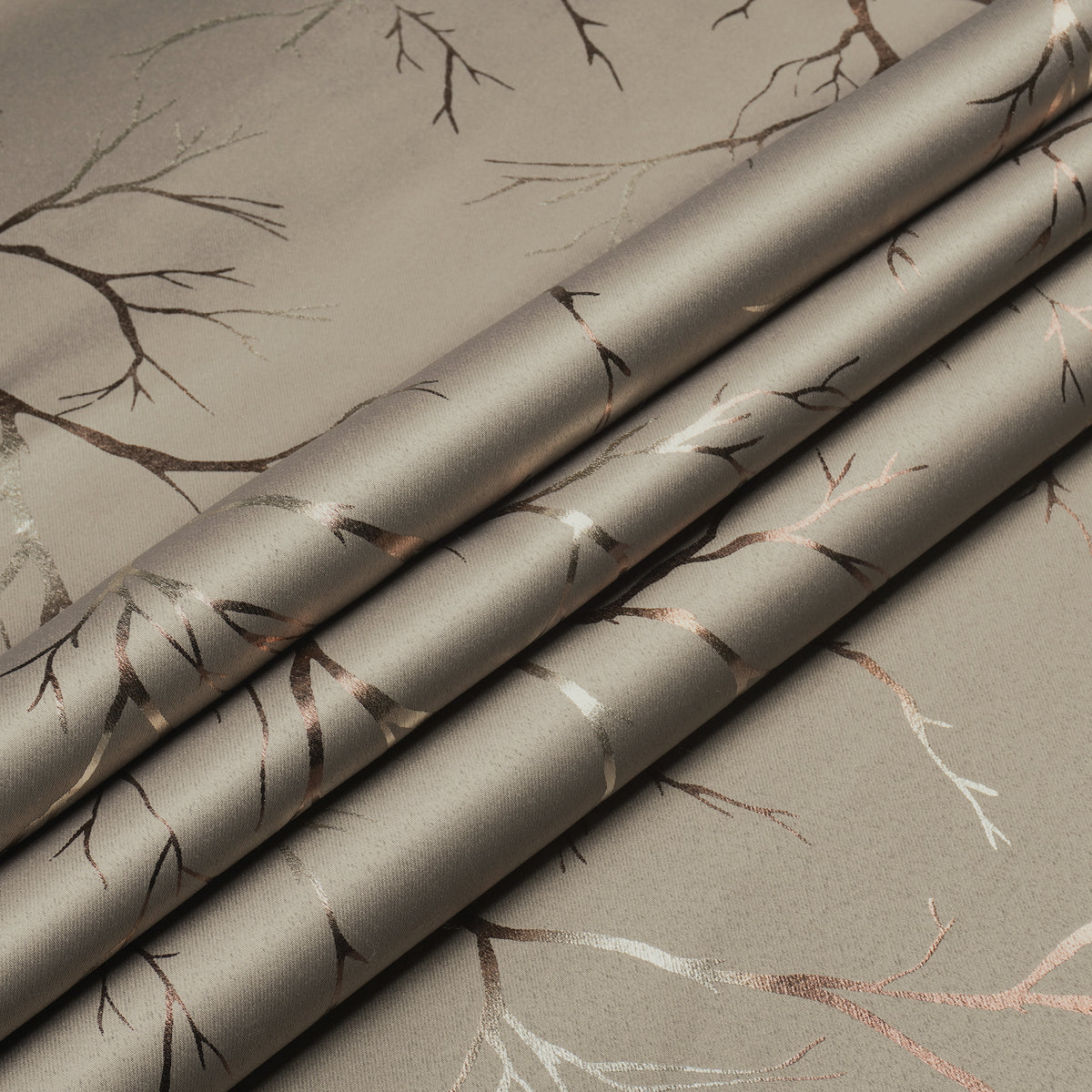 Ivory blackout curtain fabric with copper and bronze foil branch pattern, shown folded in close-up view