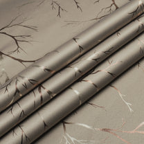 Ivory blackout curtain fabric with copper and bronze foil branch pattern, shown folded in close-up view
