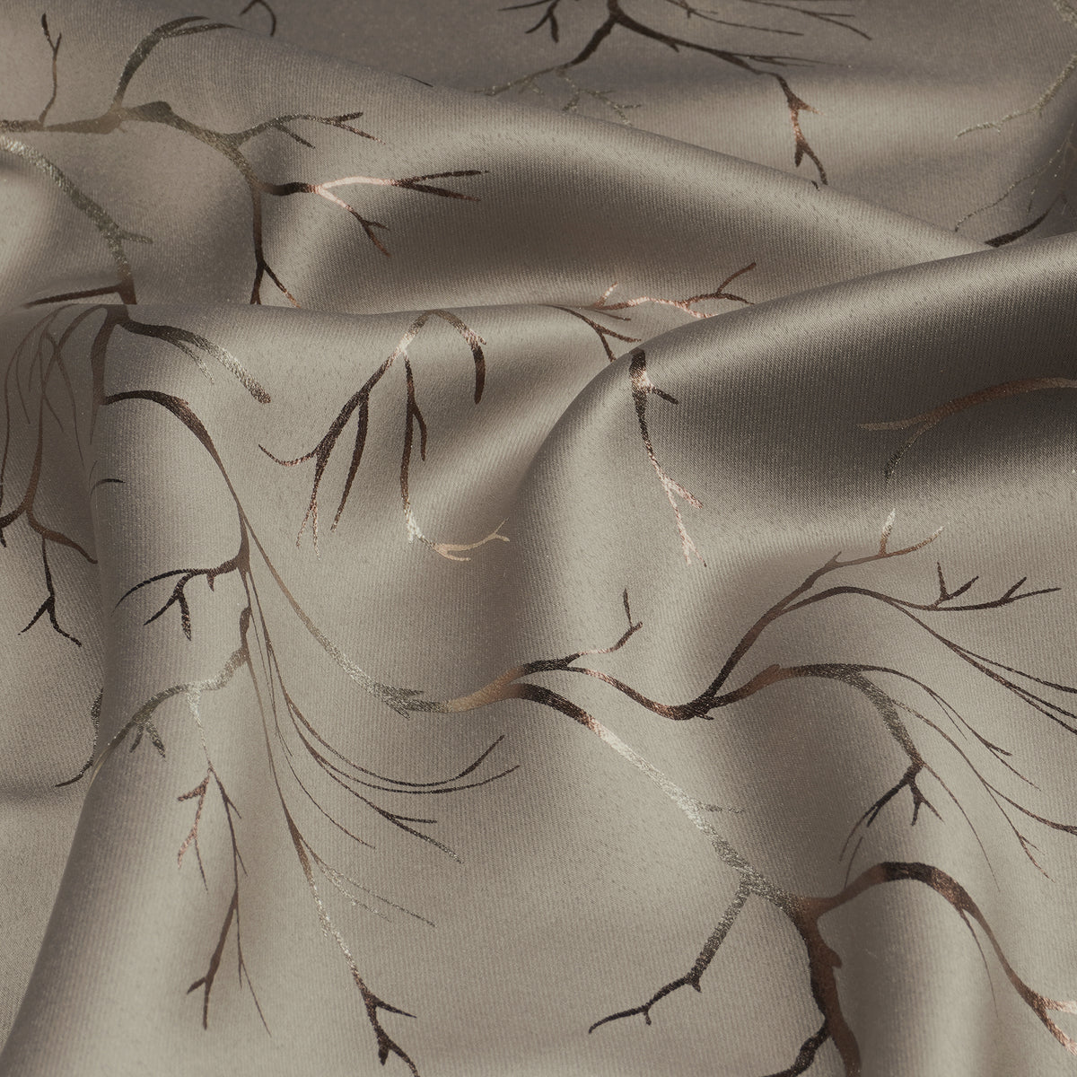 Ivory blackout curtain fabric with copper and bronze foil branch pattern, shown in a close-up folded view