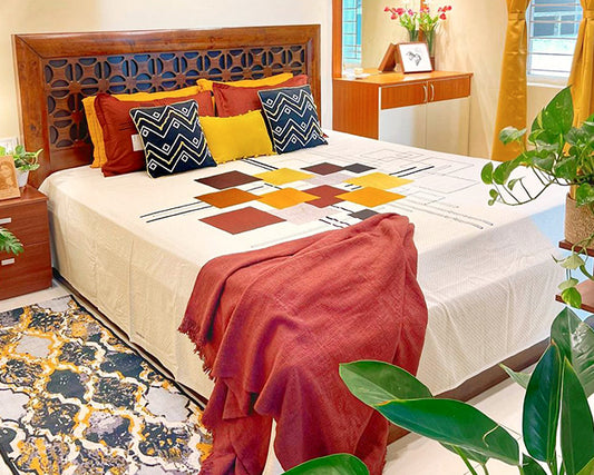 A stylish bedroom with a wooden bed, colorful pillows, patterned blanket, and decorative plants nearby.